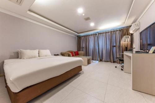 a bedroom with a bed and a tv in a room at Metro Tourist Hotel Cheonan in Cheonan