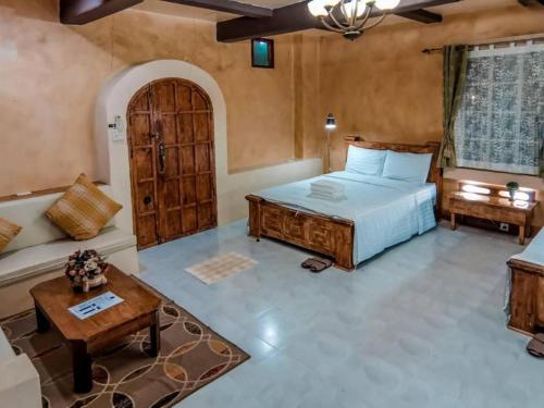 un dormitorio con una cama y un sofá en Villa Tuscany Country Resort, en Ratchaburi