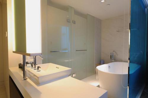 a white bathroom with a sink and a shower at Jinjiang Metropolo Hotel Classiq Shanghai Off Bund in Shanghai