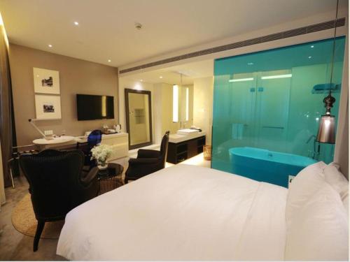 a bedroom with a bed and a bathroom with a tub at Jinjiang Metropolo Hotel Classiq Shanghai Off Bund in Shanghai