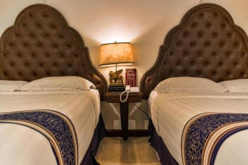 a hotel room with two beds and a lamp at Subic Bay Venezia in Olongapo