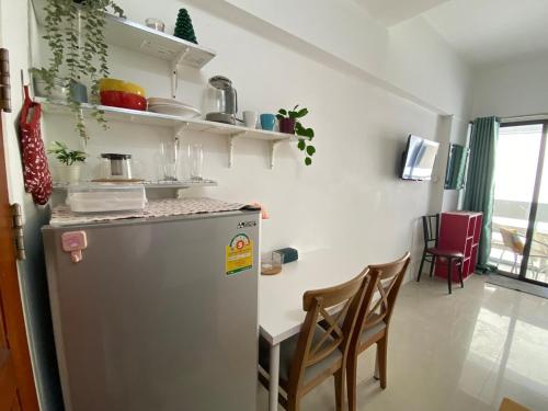 a kitchen with a refrigerator and a table with chairs at Tiny Nest Pratunum Airport Link in Pratunam