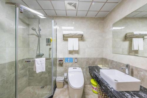 a bathroom with a shower and a toilet and a sink at Yanji Yanbian International Hotel in Yanji