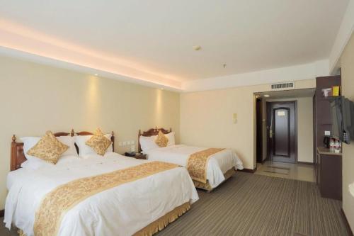 a hotel room with two beds and a television at Yanji Yanbian International Hotel in Yanji