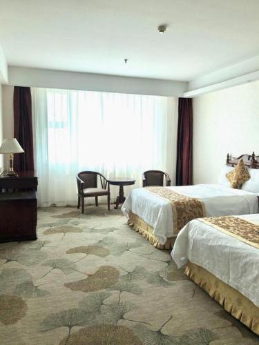 a hotel room with two beds and a table at Yanji Yanbian International Hotel in Yanji