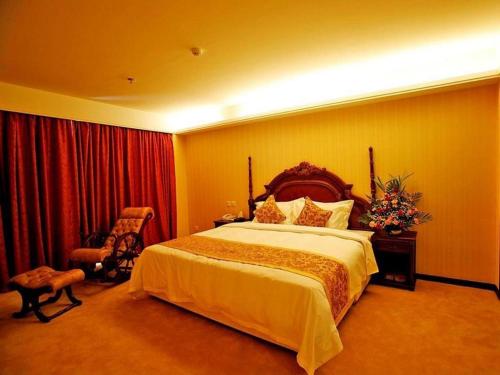 a bedroom with a large bed and a chair at Yanji Yanbian International Hotel in Yanji