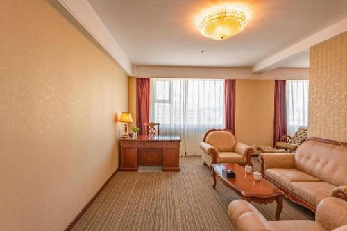 a living room with couches and chairs in a room at Yanji Yanbian International Hotel in Yanji