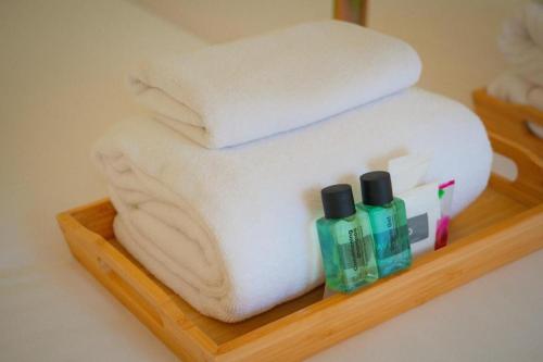 a wooden shelf with towels and bottles of soap at Bangsaen Villa Hotel in Si Racha