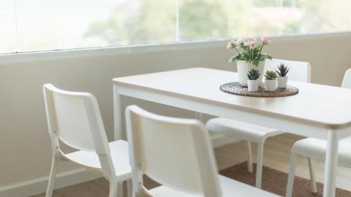 a white table with white chairs and flowers on it at Bangsaen Villa Hotel in Si Racha