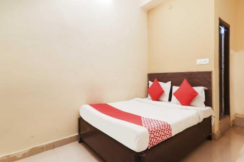 a bedroom with a bed with red pillows at Hotel O Sai Pariwar in Vidya Nagar