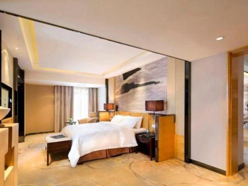 una camera da letto con un letto grande e una grande finestra di Urumqi Tianyuan Hotel a Ürümqi