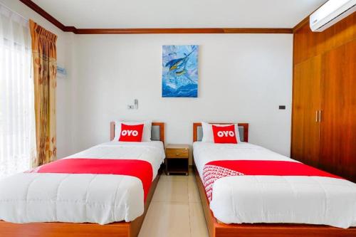 two beds sitting next to each other in a room at OYO 732 Juthamas Hotel in Patong Beach