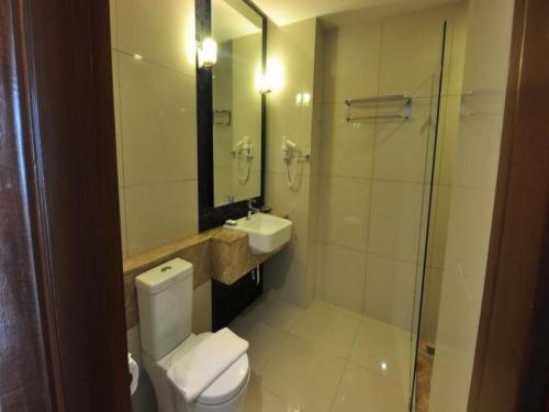 a bathroom with a toilet and a sink and a shower at Tanzeno Hotel in Nong Khai