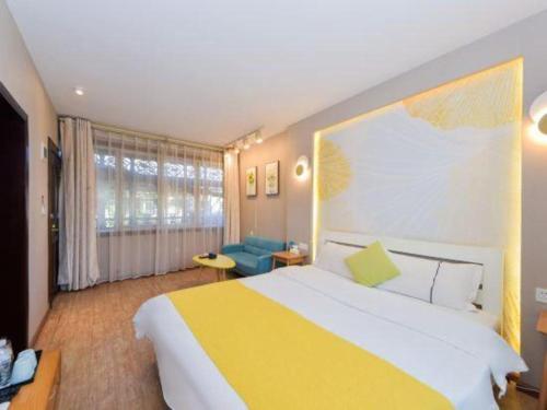 a bedroom with a large bed and a blue couch at Dali Four Seasons Hostel in Dali Ancient Town