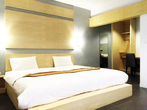 a bedroom with a large white bed in a room at NH Elegant Hotel in Sakon Nakhon