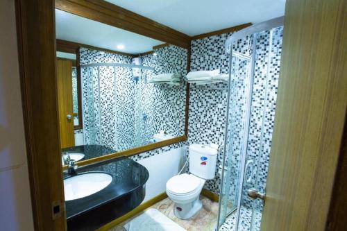a bathroom with a toilet and a sink and a shower at NH Elegant Hotel in Sakon Nakhon