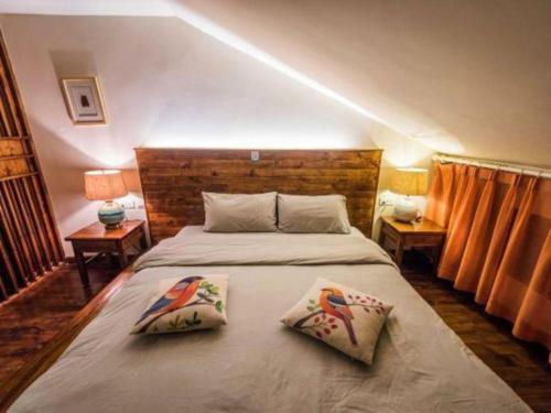 a bedroom with a bed with two pillows on it at Dali Four Seasons Hostel in Dali Ancient Town