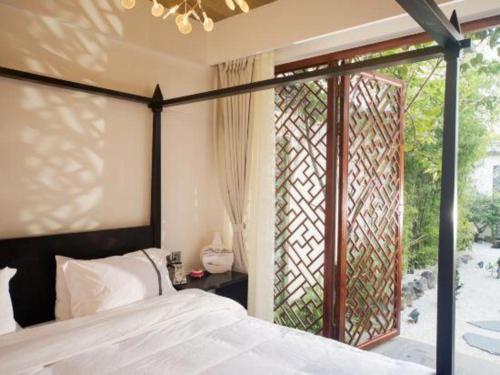 a bedroom with a bed and a large window at Dali Four Seasons Hostel in Dali Ancient Town
