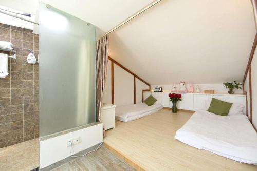 a room with two beds and a shower at Dali Four Seasons Hostel in Dali Ancient Town