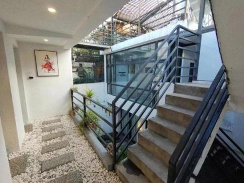 a staircase in a house with a glass railing at Dali Four Seasons Hostel in Dali Ancient Town