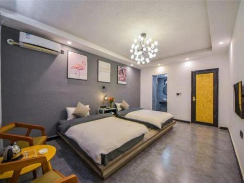 a bedroom with two beds and a chandelier at Dali Four Seasons Hostel in Dali Ancient Town
