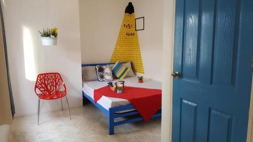a room with a bed with a table and a chair at The Sugar Hostel in Nonthaburi