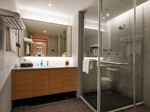 a bathroom with a shower and a toilet and a sink at New Century Kylie Hotel Ningbo in Ningbo