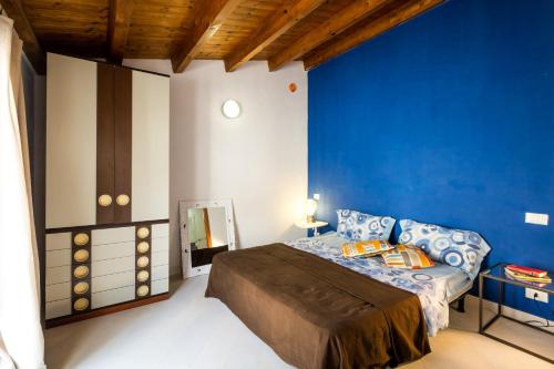 カステッランマーレ・デル・ゴルフォにあるPalazzina Luminosaの青い壁のベッドルーム(ベッド1台付)