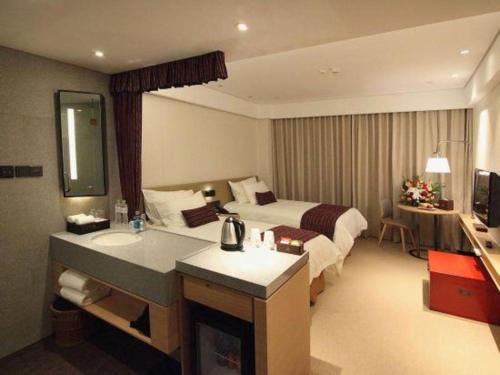 a hotel room with a bed and a sink at New Century Kylie Hotel Ningbo in Ningbo