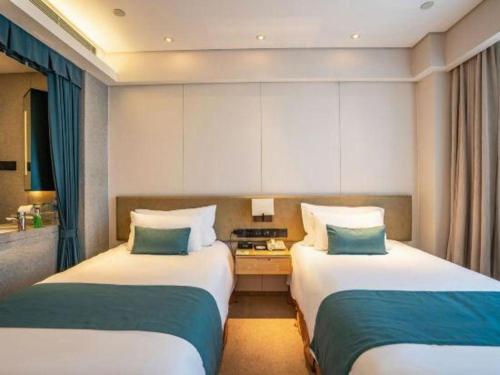 a hotel room with two beds in a room at New Century Kylie Hotel Ningbo in Ningbo