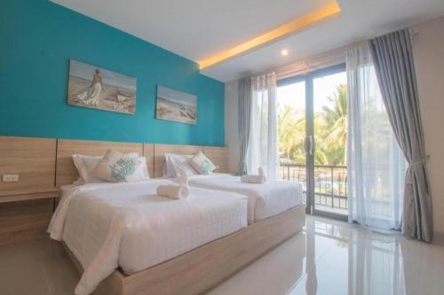 a bedroom with two beds and a large window at SEESEA RESORT in Amphoe Langu