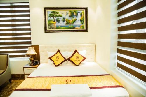a bedroom with a bed and a picture on the wall at BACNINH HARMONY HOTEL in Bắc Ninh