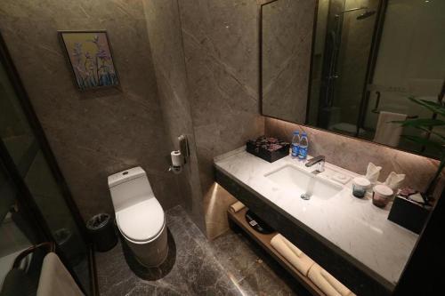 a bathroom with a toilet and a sink and a mirror at Rosedale Hotel Taicang in Taicang