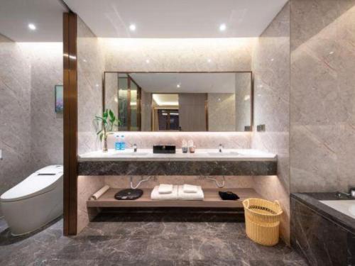 a bathroom with a sink and a tub and a toilet at Rosedale Hotel Taicang in Taicang
