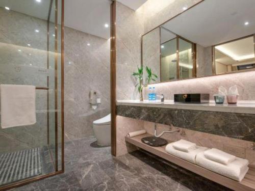 a bathroom with a shower and a sink and a toilet at Rosedale Hotel Taicang in Taicang