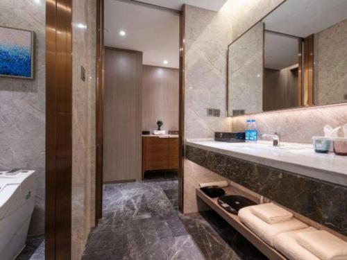 a bathroom with a sink and a tub and a mirror at Rosedale Hotel Taicang in Taicang