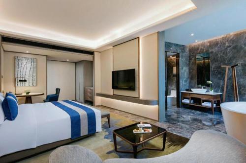 a hotel room with a large bed and a bathroom at Rosedale Hotel Taicang in Taicang