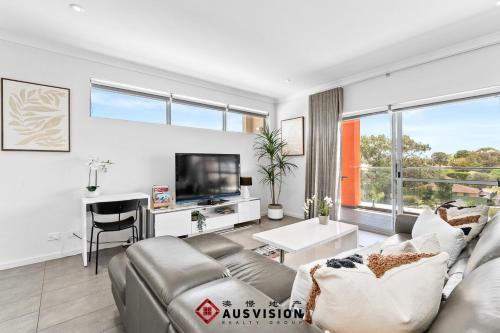 a living room with a couch and a tv at Lakeside Executive Retreat near Westfield Shops in Perth