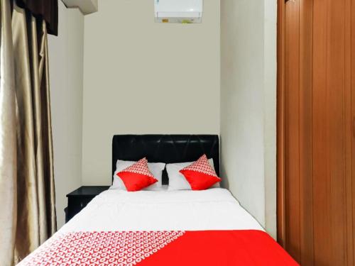 a bed with red pillows in a room at OYO 91296 Nagoya Guesthouse in Nagoya
