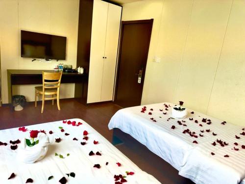 een hotelkamer met twee bedden met bloemen erop bij Hotel 007 in Sihanoukville