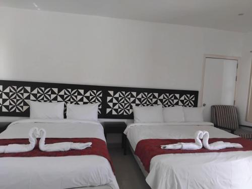 two beds in a room with swans on them at Best View Apartments in Nadi