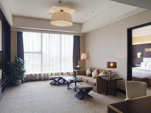 a living room with a couch and a bed at Datong Hotel in Datong