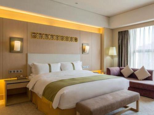a hotel room with a large bed and a couch at Datong Hotel in Datong