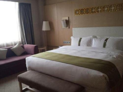 a hotel room with a large bed and a couch at Datong Hotel in Datong