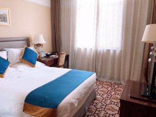 a hotel room with a large bed and a window at Datong Hotel in Datong