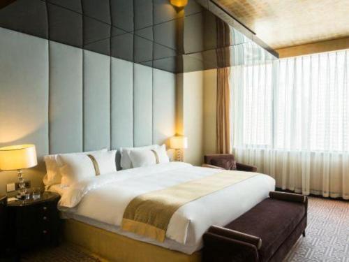 a bedroom with a large bed and a large window at Datong Hotel in Datong