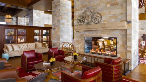 a living room with a fireplace and red chairs at Hyatt Regency Changbaishan in Fusong