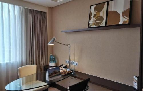 a room with a desk with a lamp and a chair at Datong Hotel in Datong