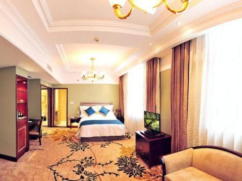 a bedroom with a bed and a couch in a room at Datong Hotel in Datong
