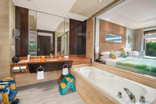 a bathroom with a large tub and a bed at New Century Grand Hotel Xuzhou in Xuzhou